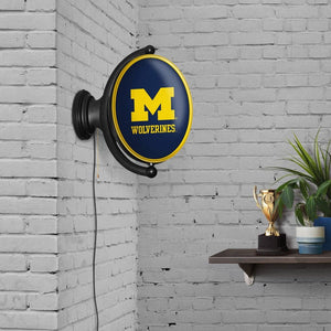 Michigan Wolverines: Maize - Original Oval Rotating Lighted Wall Sign - The Fan-Brand