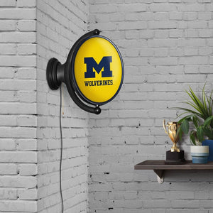 Michigan Wolverines: Maize - Original Oval Rotating Lighted Wall Sign - The Fan-Brand